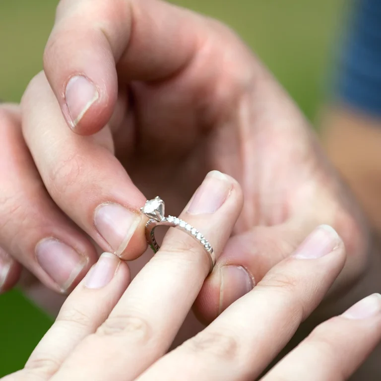 man-placing-a-diamond-engagement-ring-on-the-finger-of-his-fiance-shallow-depth-of-fie-SBI-301045830 copy