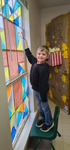 During Catholic School Week, a student in PK4B helped to paint stained glass windows of the PK Building as a class project.It was supervised by PK4B teacher Mrs. Ashley Foret.